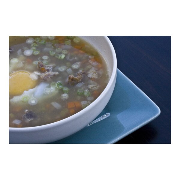 cooked turtle soup with a poached duck egg in a white bowl