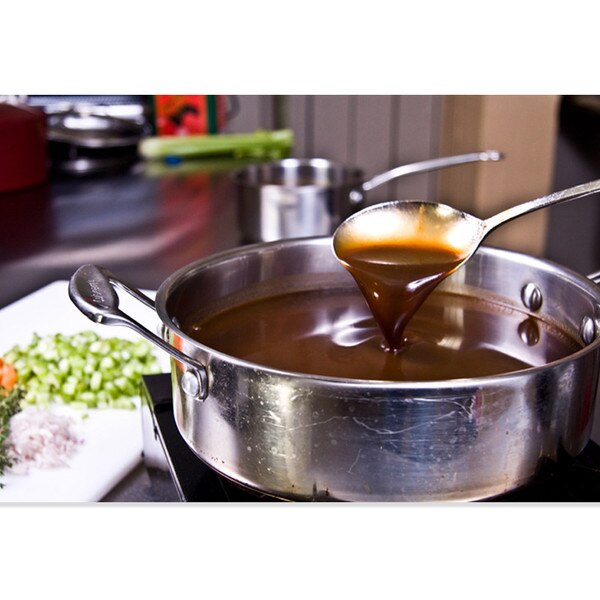 Pot of pure veal demi-glace, spoon, side plate of chopped celery, carrot & herbs, sauce pot in background