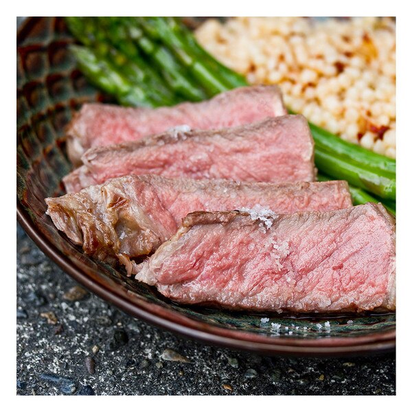 sliced beef striploin, asparagus & couscous, round plate