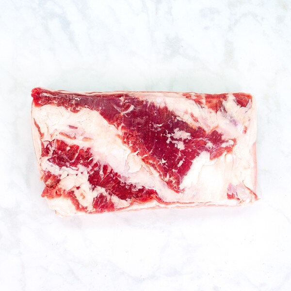 Rectangular slab of raw Spanish Iberico pork belly on marble background