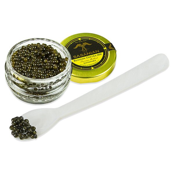 grains of caviar on the tip of a spoon next to an open jar of Russian Osetra 000 caviar