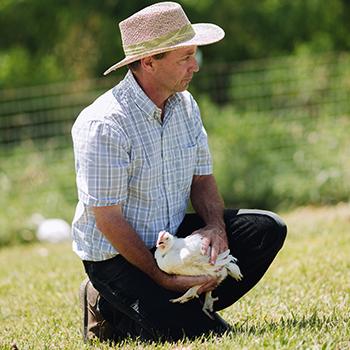 SVO Farmer holding a chicken