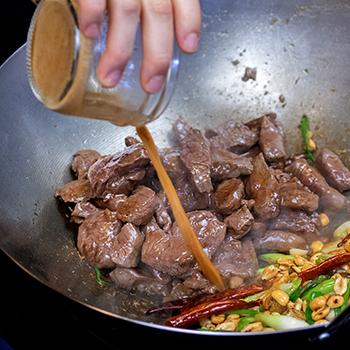 kung pao venison being cooked in a wok