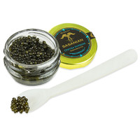 Opened jar of osetra supreme caviar along with grains of caviar on the tip of a white spoon.