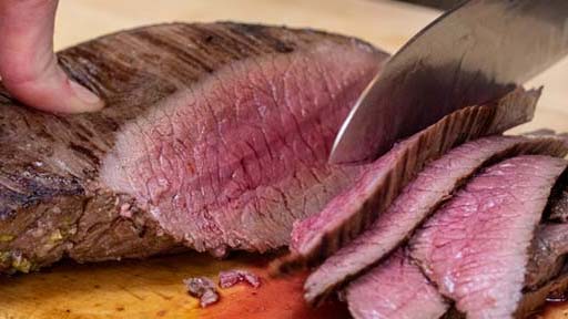 slicing venison on cutting board