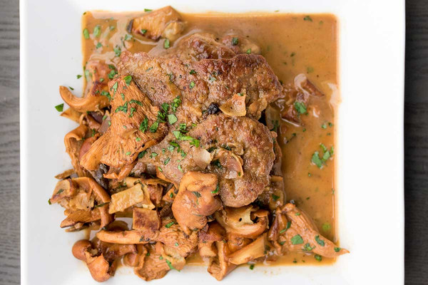Grain-fed veal cutlet marsala with chanterelles, parsley, square white plate