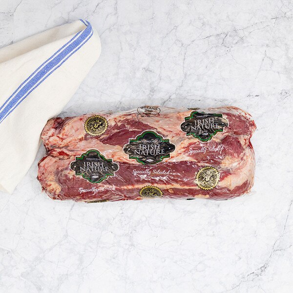 One vacuum-sealed package of Irish Nature beef hanger steaks on marble background with blue-striped kitchen towel.