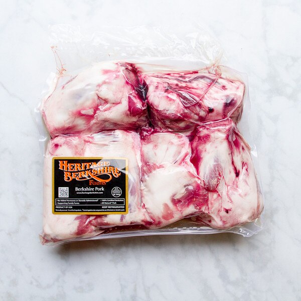 Package of 6 raw, Kurobuta Berkshire pork hindshanks with label on marble background