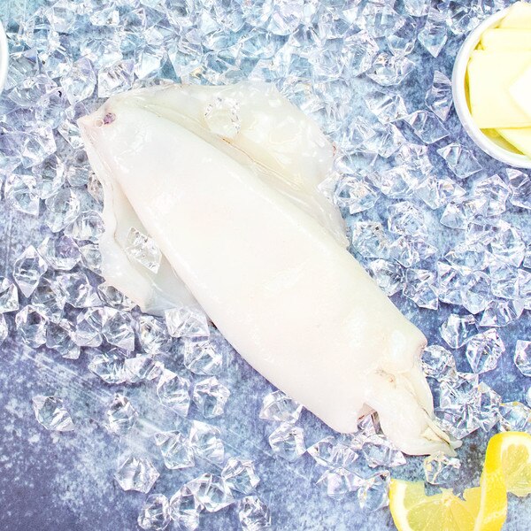 1 raw cleaned Spanish squid on ice with butter and a lemon peel