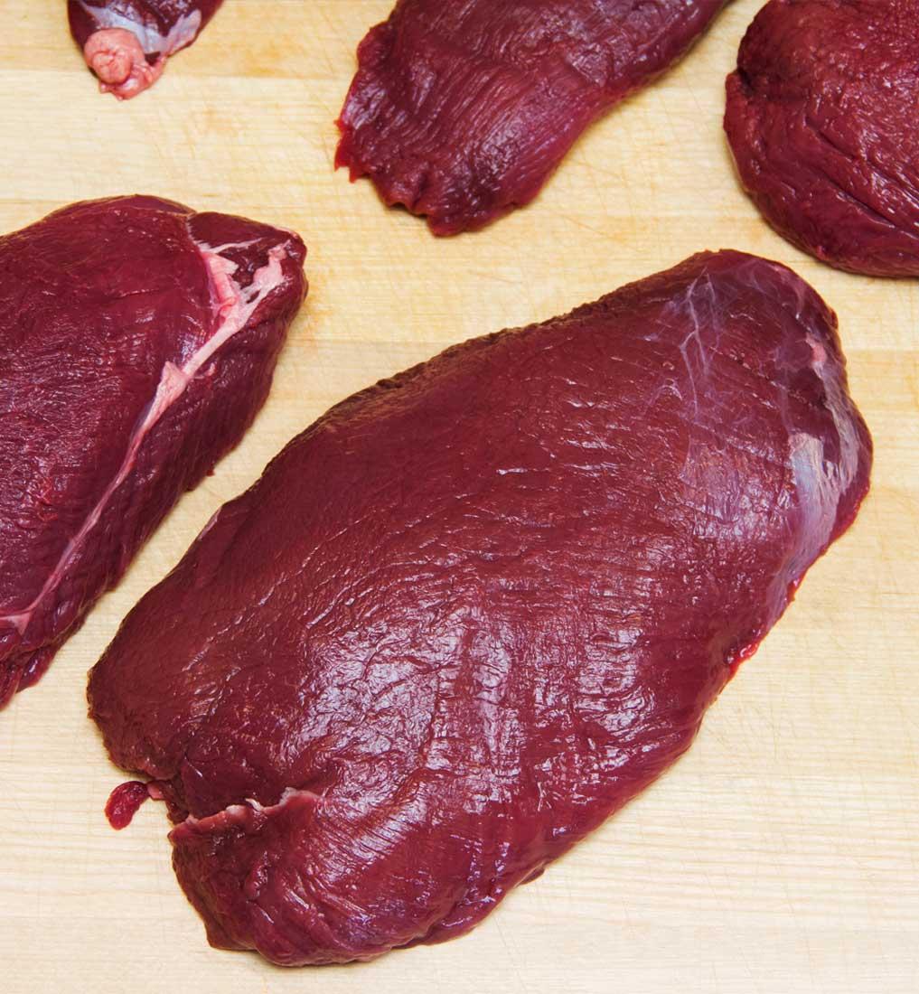 portioned venison on butcher block